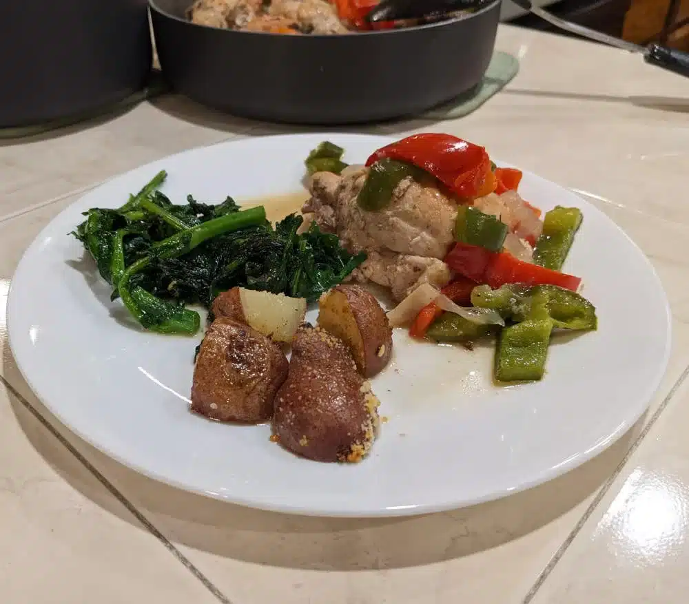 Plate of Chicken Cacciatore with Oven Roasted Potatoes and Broccoli Rabe.